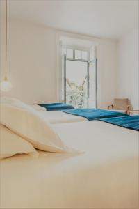 a white bed with blue sheets in a room at Comercial Azores Boutique in Ponta Delgada