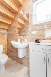 a bathroom with a white sink and a toilet at Domki Miłe. Lubiatowo in Lubiatowo