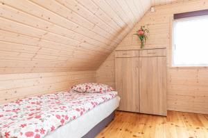 ルビャトボにあるDomki Miłe z basenem - Lubiatowoのベッドと木の壁がある寝室 +44枚の写真