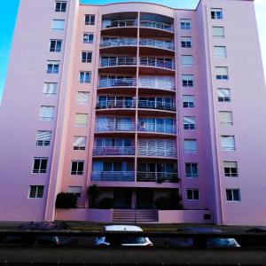 an apartment building with a pink at Sunset House Azores in Ponta Delgada