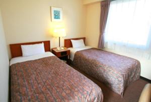 a hotel room with two beds and a window at Star Hotel Koriyama in Koriyama