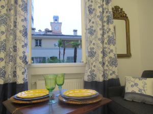 a table with plates and glasses and a window at Le Ptit Niçois sur le Port in Nice