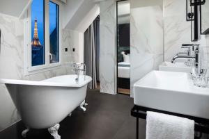 W łazience znajduje się wanna, umywalka i lustro. w obiekcie Maison 46 w Paryżu