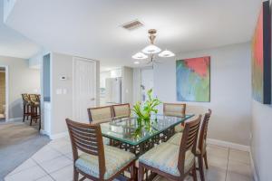 a dining room with a glass table and chairs at Gull Wing Beach in Fort Myers Beach