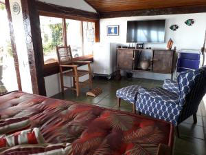 a living room with a couch and a tv at Casa das Ilhas in Ilhabela