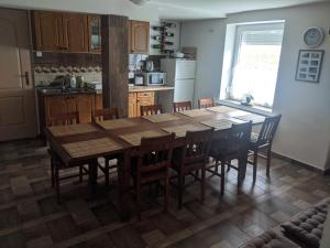 una cocina con una gran mesa de madera y sillas en Római Fürdő Apartmanház, en Bakonynána