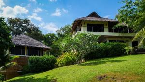 a house on a grassy hill next to a building at Koh Yao Sunrise Villa in Ko Yao Noi