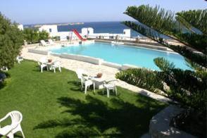 a large swimming pool with white chairs in a yard at Silver Rocks Hotel in Chrissi Akti