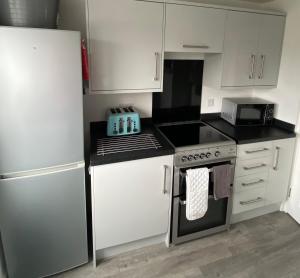 a kitchen with a stove top oven next to a refrigerator at Surf's Up in Perranporth, Cornwall Coastal Holidays in Perranporth