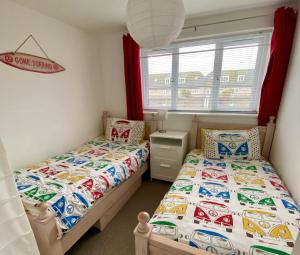 a bedroom with two beds and a window at Surf's Up in Perranporth, Cornwall Coastal Holidays in Perranporth