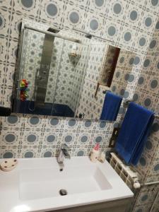 een badkamer met een witte wastafel en een spiegel bij A casa di marcello in Catanzaro