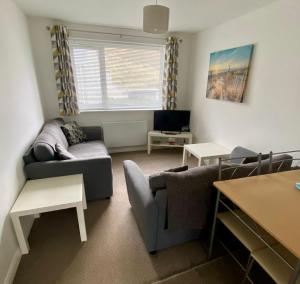 a living room with a couch and a tv at Surf's Up in Perranporth, Cornwall Coastal Holidays in Perranporth