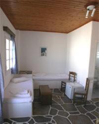 a bathroom with a toilet and a chair in a room at Silver Rocks Hotel in Chrissi Akti