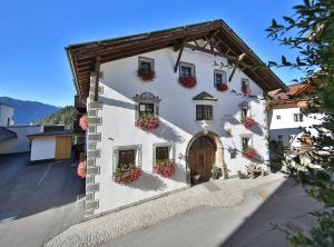 a white building with flower boxes on it at Hotel Pension Geiger in Serfaus