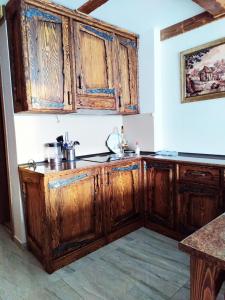 a kitchen with wooden cabinets in a room at Light Apartments in Gudauri