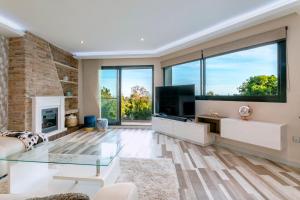 a living room with a fireplace and a television at Luxury villa with sea views - heated pool-Jacuzzi in Benalmádena