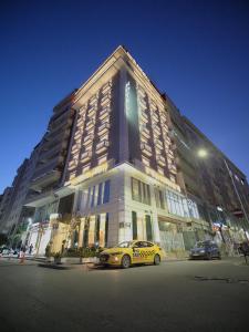 a yellow taxi cab parked in front of a building at Light Hotel in Tirana