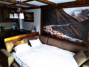 a bed in a room with a large painting on the wall at Light Apartments in Gudauri