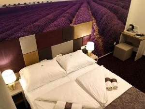a bedroom with a large bed with a purple wall at Hotel & Spa Villa Meydan in Mostar