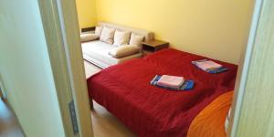 a bedroom with a red bed and a couch at Apartmán Karin in Oščadnica
