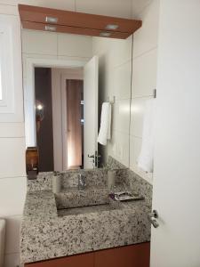 a bathroom with a sink and a mirror at Casa Linda Canela condomínio!!! 39 in Canela