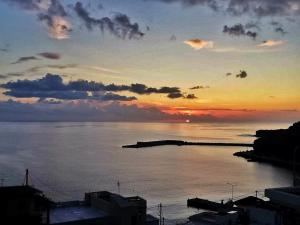 a sunset over a large body of water at Dorana Apartments & Trekking Hotel in Diafani