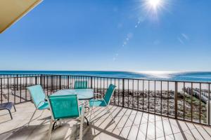 uma varanda com mesa e cadeiras e a praia em Phoenix Vacation Rentals em Orange Beach