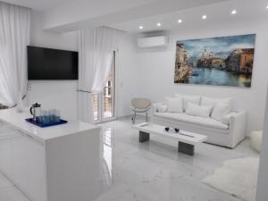 un soggiorno bianco con divano e tavolo di Despina's Lux apt Downtown a Heraklion