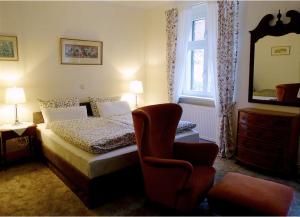 1 dormitorio con cama, silla y espejo en Pension Gräfliche Villa en Reitwein