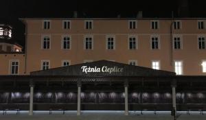a building with a sign on top of it at night at Apartament Przy Promenadzie in Jelenia Góra