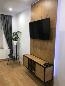 a living room with a flat screen tv on a wall at Apartament Przy Promenadzie in Jelenia Góra