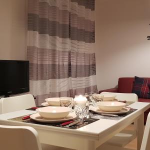 a white table with white dishes and candles on it at Sweet Home in Falconara Marittima