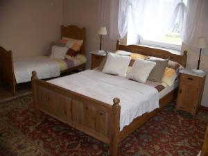 a bedroom with two beds and a window at Pałac Dąbrowica in Dąbrowica