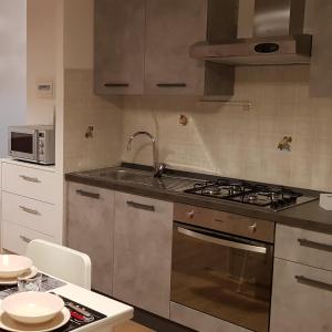 uma cozinha com um lavatório e um fogão forno superior em Sweet Home em Falconara Marittima