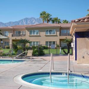 a villa with a swimming pool and a building at Raintree's Cimarron Golf Resort Palm Springs in Cathedral City