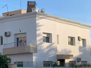 un edificio blanco con balcón en la parte superior en Au Cœur Des Plages de Rabat en Oulad Kerroum