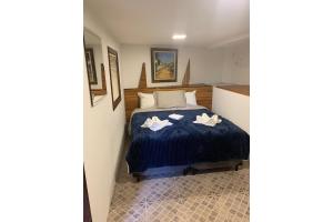 um quarto com uma cama com duas flores brancas em Chalé Privativo em complexo 1,2 km Capivari em Campos do Jordão