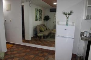 a kitchen with a refrigerator and a living room at New Fez Apartments in Fez