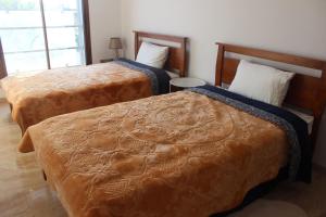 2 camas en una habitación de hotel con ventana en New Fez Apartments en Fez