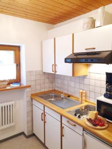 cocina con fregadero y fogones en Haus Andrea, en Fischen