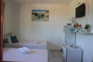 ニテロイにあるPousada Piratiningaのベッド2台が備わる部屋、壁に自転車の写真が飾られています。