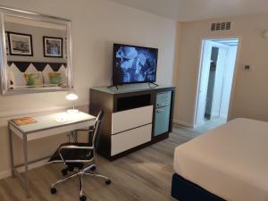 1 dormitorio con 1 cama y escritorio con TV en Kings Inn, en San Diego