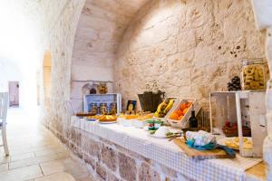 a table with food on it in a stone wall at Relais La Masseriola in Castellana Grotte +44 photos