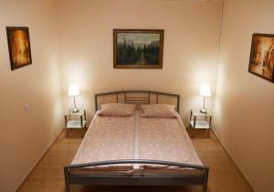 1 dormitorio con 1 cama con 2 lámparas en la pared en CasaMia-Elegant Central Vaci St.Apt, en Budapest