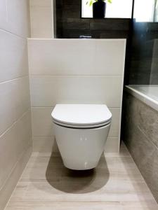 a bathroom with a white toilet and a bath tub at Kings Lynn, Double bedroom, newly renovated bathroom in King's Lynn