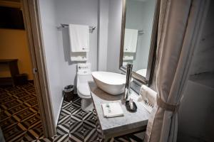 W łazience znajduje się umywalka, toaleta i lustro. w obiekcie Hotel Esfera Tulancingo w mieście Tulancingo