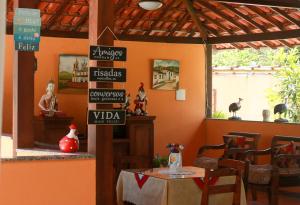 un ristorante con tavolo e un cartello sul muro di Pousada Piratininga a Niterói