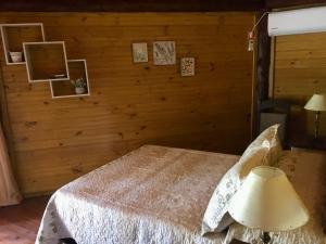 1 dormitorio con 1 cama en una pared de madera en Los Quetzales, en Maldonado