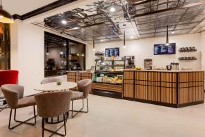 a restaurant with a table and chairs and a counter at Hotel Retlaw, Trademark Collection by Wyndham in Fond du Lac