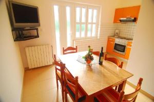 eine Küche mit einem Esstisch und einem TV in der Unterkunft Apartment Bela1 - close to the beach in Trogir